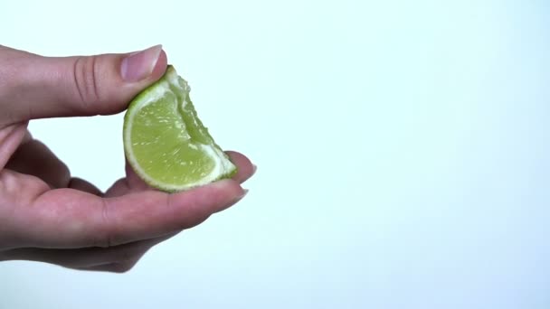 Espremer um pedaço de limão com sucos esguichando — Vídeo de Stock