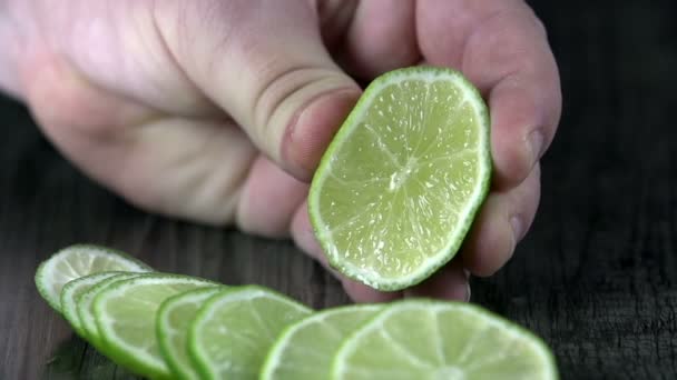 Hand squeezing a slice of lime in slow motion — Stock Video