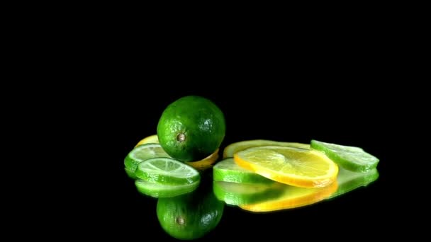 Whole lime falls onto pile of citrus slices on the table — Stock Video