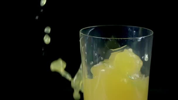 Slice of lime falls into juice and spills it over the edge — Stock Video