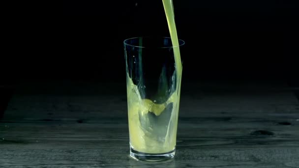 El jugo de cítricos se vierte en un vaso vacío — Vídeo de stock