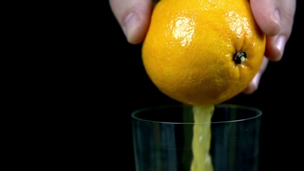 Steady flow of juice puring into glass out of an organge in slow motion — Stock Video
