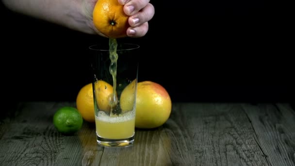 Сок от сжатия апельсин течет информация чашку — стоковое видео