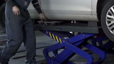 Auto makinist araba asansörleri ve jantlar kaldırır