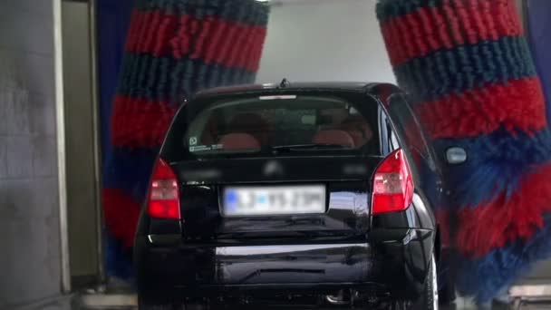Big blue-red brushes cleanse the car from both sides in slow motion — Stock Video