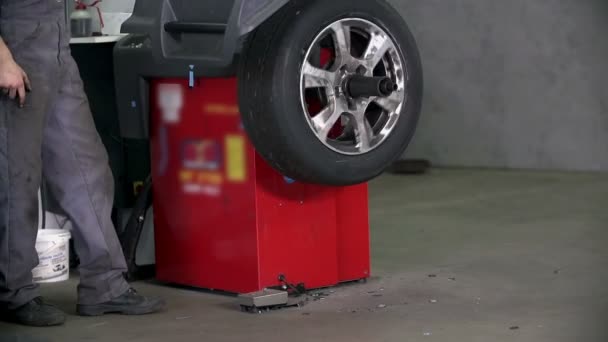 Vulkanisierer überprüft den Reifen und richtet ihn auf — Stockvideo