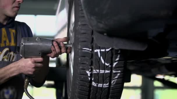 Mechanic loosening the car's tire — Stock Video