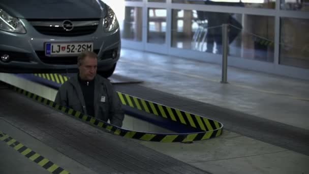 Ο μηχανικός έρχεται κάτω από το αυτοκίνητο. . — Αρχείο Βίντεο