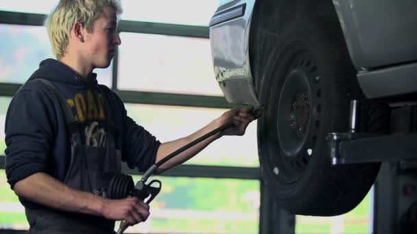 Vulcanizador joven inflando los neumáticos en cámara lenta — Vídeos de Stock