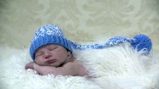Resting baby in winter scene with a blue cap on his head