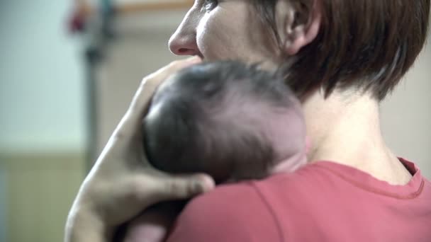 Mutter hält ihr Baby neben der Schulter — Stockvideo