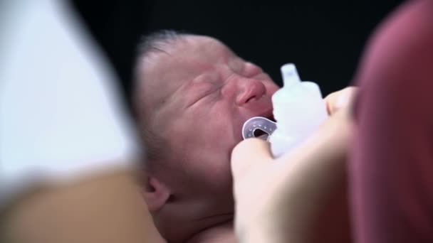 Moeder geeft haar baby een fopspeen — Stockvideo