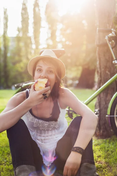 Femme sur l'herbe et manger de la pomme — Photo