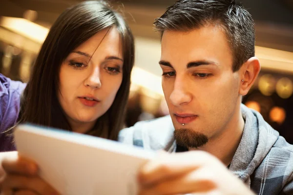 Hombre y mujer usando la tableta en un café — Foto de Stock