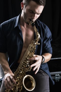 Genç adam saksafon çalıyor..