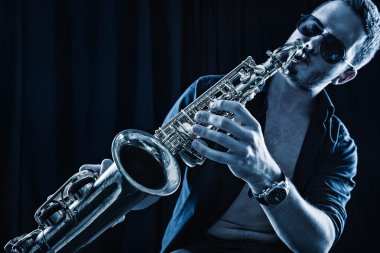 Young man playing the Saxophone. clipart