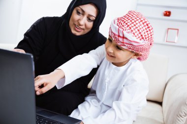 Arabic mother and son using laptop clipart