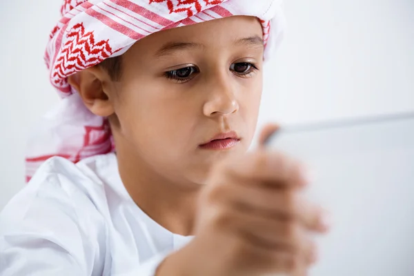 Арабский мальчик играет на планшете — стоковое фото