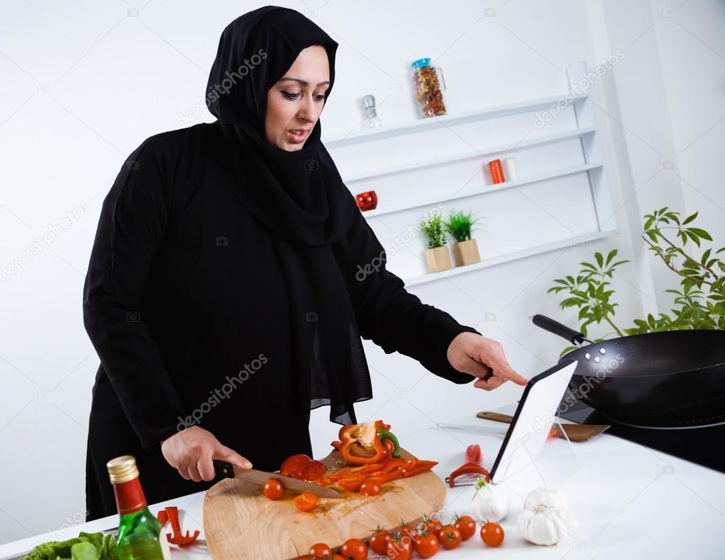 Arabian woman cooking in kitchen