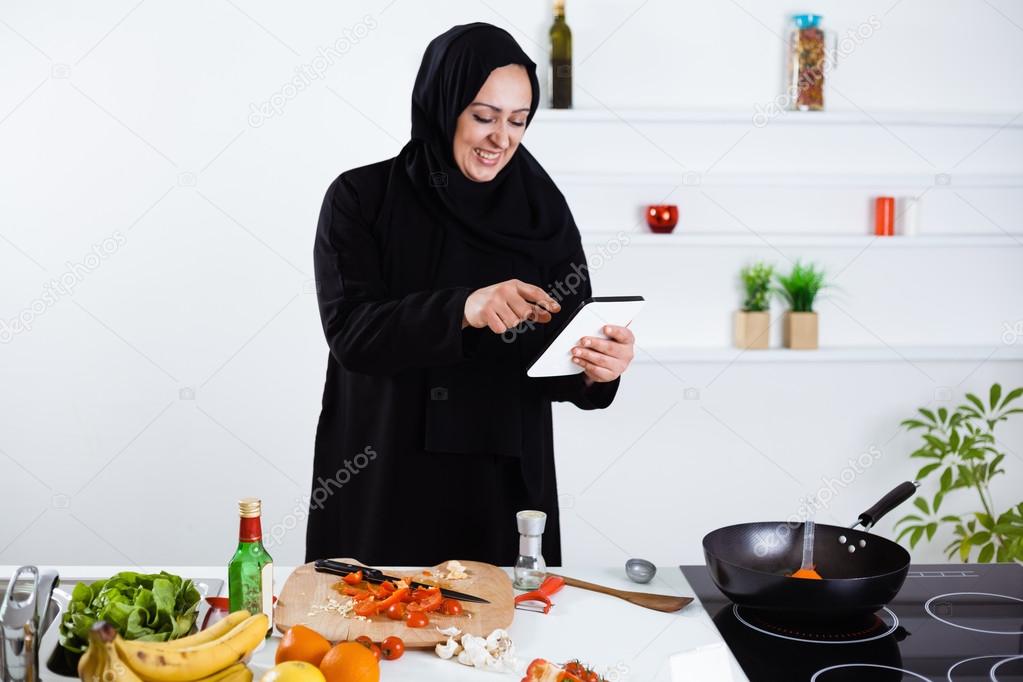Arabian woman cooking in kitchen