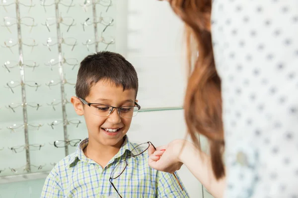 Junge probiert Brille mit Mutter aus — Stockfoto