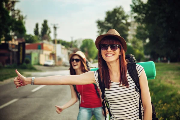 Dziewczyny turystyczny autostop na drodze — Zdjęcie stockowe