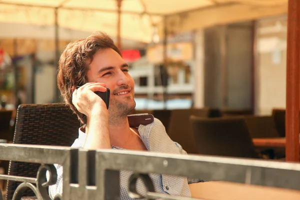 Man in cafe talking on mobile phone — Stock Photo, Image