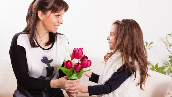 Girl giving her mother flowers — Stock Photo, Image