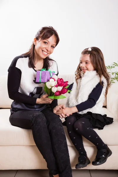 Girl giving her mother flowers — Stock Photo, Image