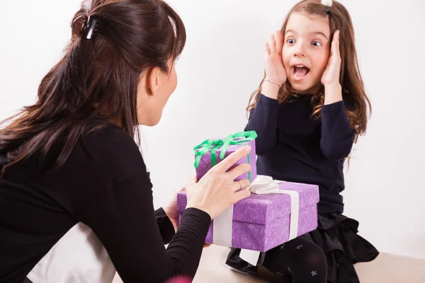 Matka dává dcera překvapení dárek — Stock fotografie