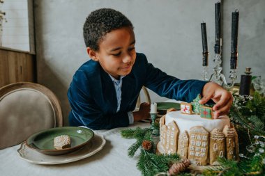 Çocuk evde zencefilli kek süslüyor. Noel zamanı aile eğlencesi konsepti. On senelik el yapımı Mutlu yıllar tatlıları..