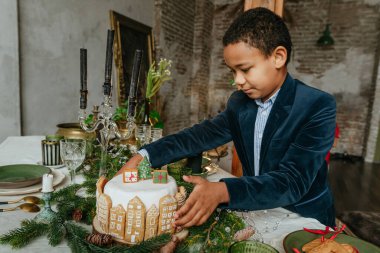 Noel pastası tutan çocuk ev yapımı zencefilli kurabiyelerle süslenmiş. On senelik el yapımı Mutlu Yıllar Şenlik Tatlıları.