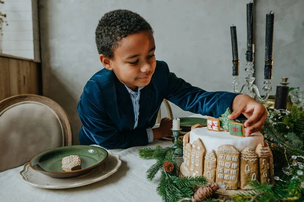 Çocuk evde zencefilli kek süslüyor. Noel zamanı aile eğlencesi konsepti. On senelik el yapımı Mutlu yıllar tatlıları..