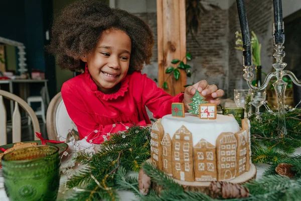 Evde zencefilli kek süsleyen kız. Noel zamanı aile eğlencesi konsepti. Küçük el yapımı mutlu yıllar tatlıları için bir fikir. Kıza odaklan..