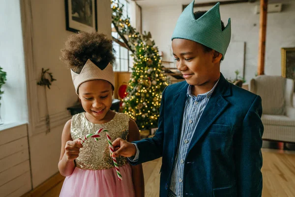 Kız ve erkek kardeşler Noel şekerlerini evde tutuyorlar..