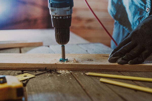 Close up of worker using electric scredriver on the table