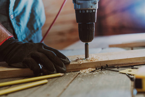 Close up of worker using electric scredriver on the table
