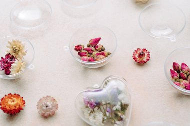 Bej beton arka planda kurumuş çiçeklerle dolu DIY süslemeleri. Noel ağacı ya da Sevgililer Günü dekorasyonu fikri. Üst manzara, düz uzanma