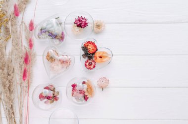 Beyaz ahşap zemin üzerinde kurumuş çiçeklerle dolu DIY süslemeleri ve metin için boş alan. Noel ağacı dekoru fikri. Üst manzara, düz uzanma.