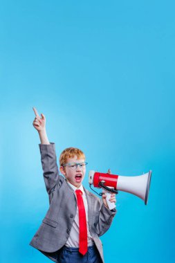 Komik kızıl saçlı genç iş adamı takım elbiseli ve mavi arka planda gözlüklü kravat takıyor ve mesaj için boş alan var.