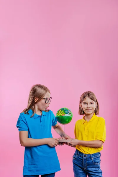 两个学生拿着他们的科学项目Diy细胞模型在粉色背景下 空白的文字空间 — 图库照片