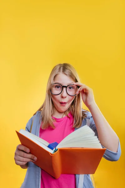 Glad Tonåring Flicka Håller Ryggsäck Läsa Bok Studio Porträtt Gul — Stockfoto