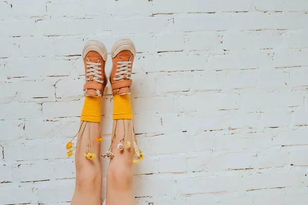 Girl Dried Flowers Yellow Socks Putting Brick White Wall Copy — стоковое фото