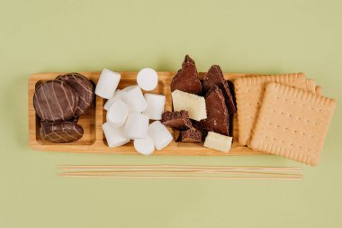 Kurabiyelerin arasında çikolatalı marşmelov kızartılan çikolatalar ve mesaj için boş alan. Üst manzara, düz uzanma.