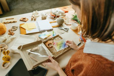 Çevre dostu paket alıcısı için paketleme yapan genç bir kadın.