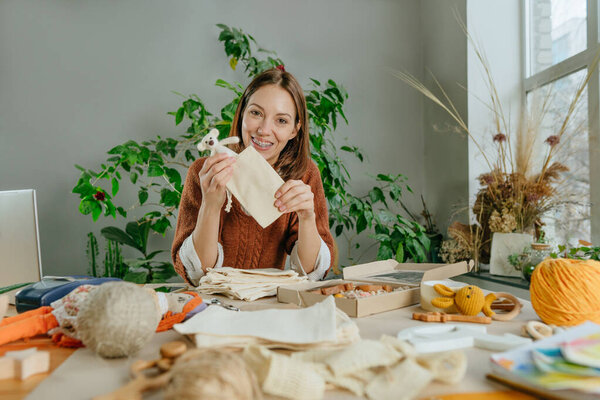 Young woman packing purchase for the buyer at eco friendly package
