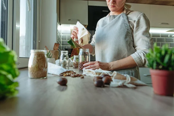 Молодая Женщина Стоящая Кухне Наливающая Бобы Многоразового Хлопкового Пакета Стеклянную — стоковое фото