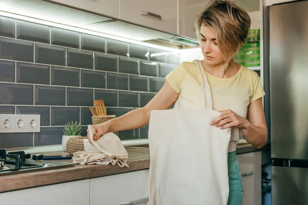 Young Woman Standing Kitchen Taking Reusable Cotton Bags Table Shopping — стоковое фото