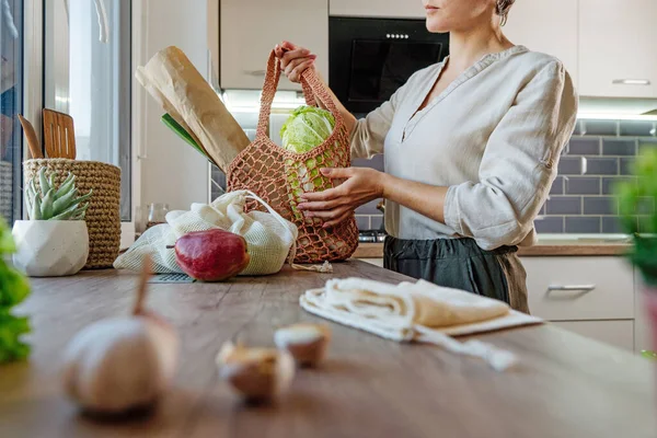 台所で果物 野菜やパンと再利用可能なメッシュバッグを保持若い女性 廃棄物ゼロ 持続可能な包装コンセプト — ストック写真