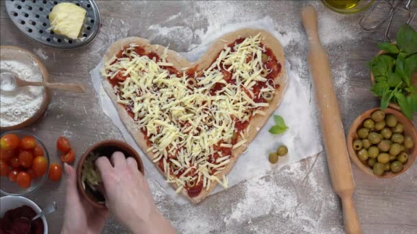 Женщина посыпает домашнюю пиццу тертым сыром — стоковое видео